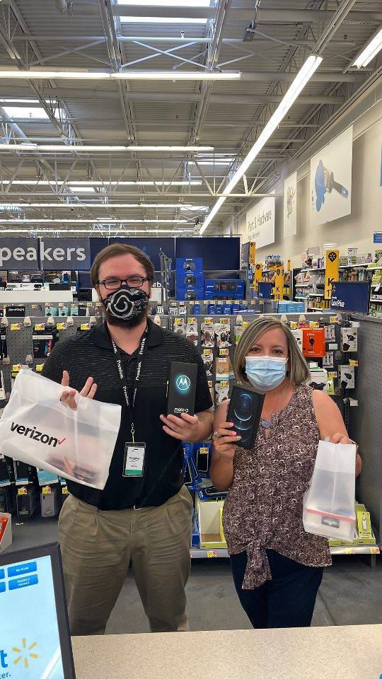 A Walmart Wireless team member helps a customer