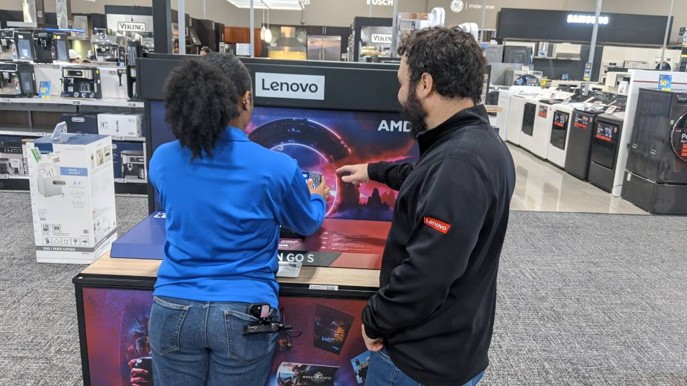 two employees looking at handheld gaming device